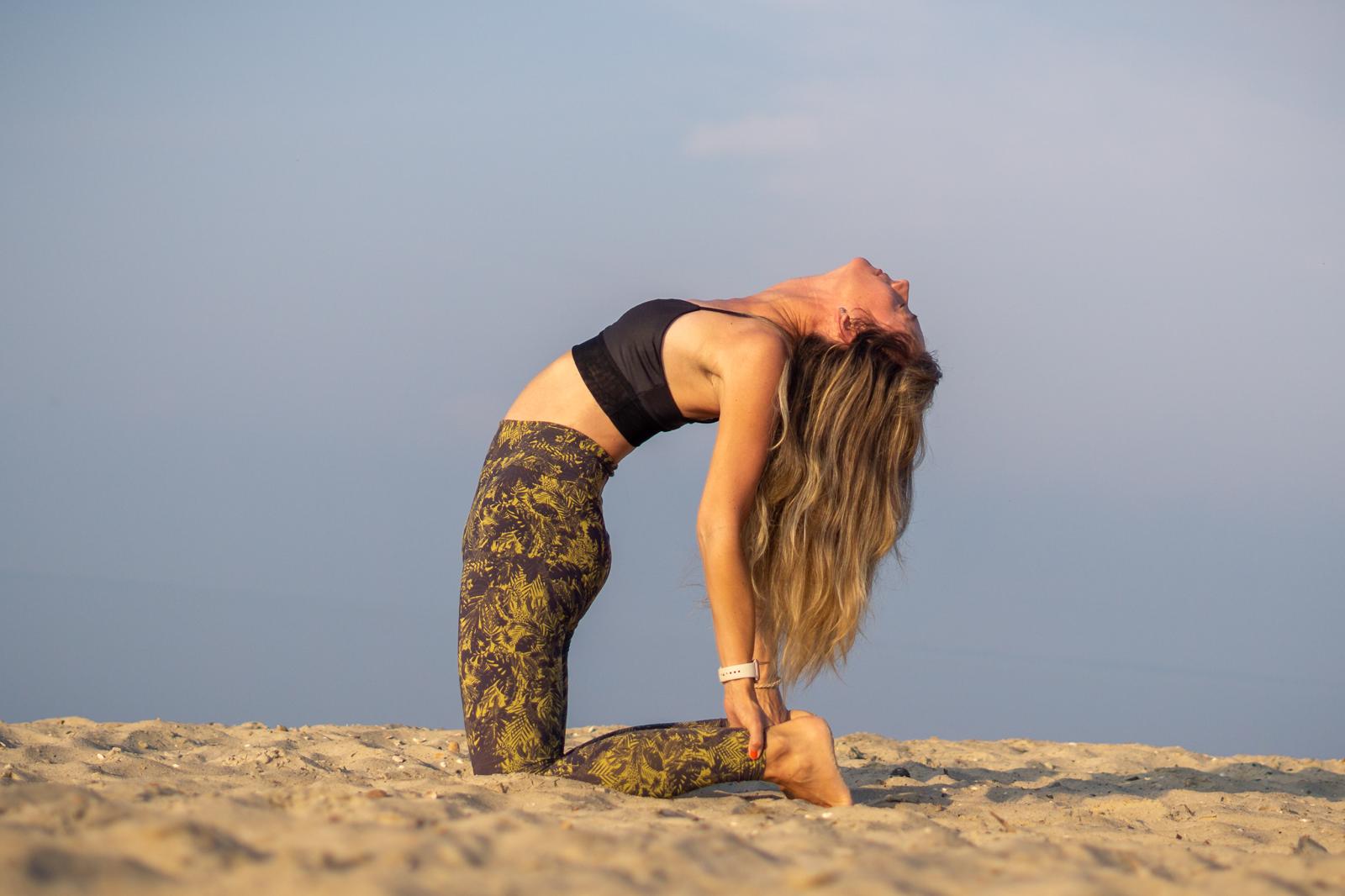 Sabine Eiswirth in der Kamelpose (Ustrasana) auf dem Sandstrand
